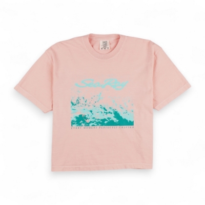 Women's Splash Tee - Peach Image of the Peach Women's Splash Tee with the Sea Ray logo and a graphic of a wave on the front. Below the graphic, the phrase "EVERY MOMENT PERFECTLY CRAFTED" is printed in small lettering