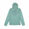 Back view of a women’s long‑sleeve hooded performance shirt in green fog color, featuring a large navy Sea Ray Owners Club graphic with a palm tree and “Since 1959” text.